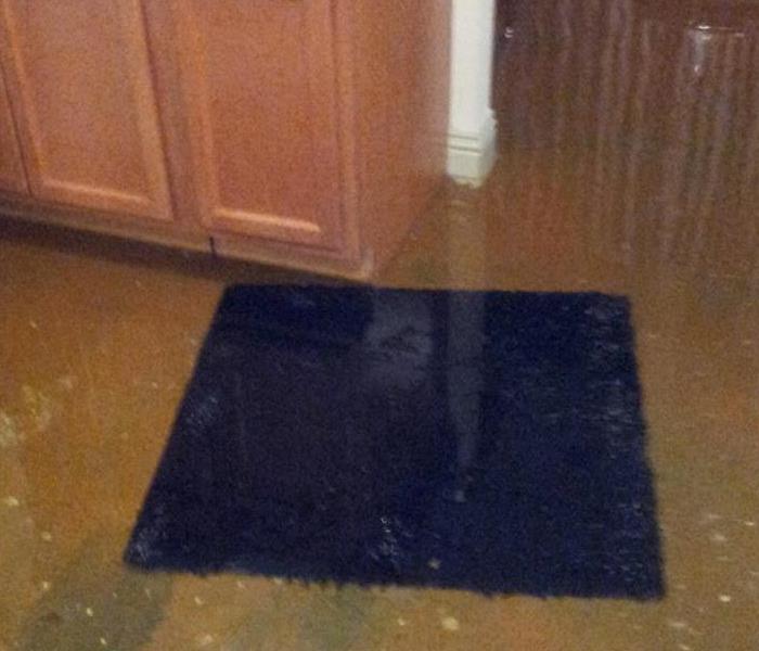 Flood water affected kitchen floor, cabinets, and walls